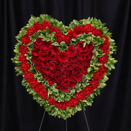 Heart-shaped red rose and carnation standing spray on an easel