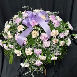 Lavender and white carnation spray with a purple ribbon