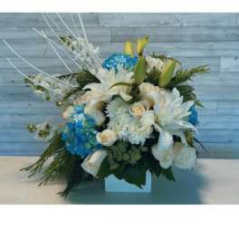 White and blue floral arrangement in a square vase