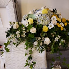 Large white and yellow funeral spray with roses, daisies, and hydrangea