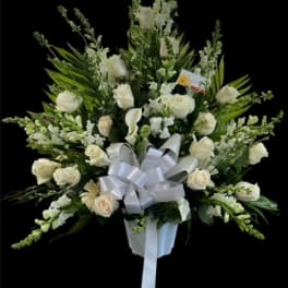 White rose and calla lily arrangement with a silver bow in a white vase