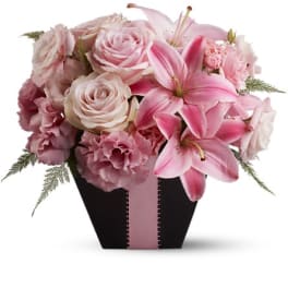 Pink lilies, roses, and carnations in a black box with a pink ribbon