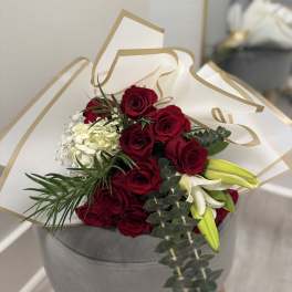 Bouquet of red roses with white lilies in white and gold wrap