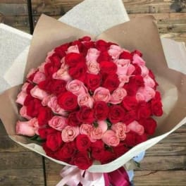 Large bouquet of red and pink roses wrapped in brown paper