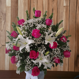Pink roses and white lilies in a vase with baby's breath