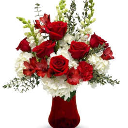 Red roses and white flowers arranged in a red vase
