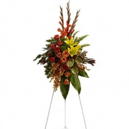Standing floral spray with red, orange, and yellow flowers on a metal easel