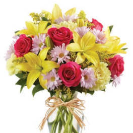 Bouquet of yellow lilies, pink roses, and daisies in a glass vase