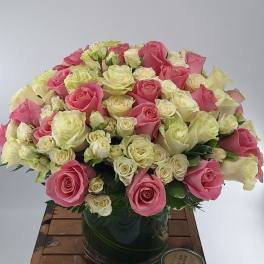 Pink and white roses arranged in a glass vase