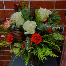 Bouquet of white roses and red carnations in a glass vase