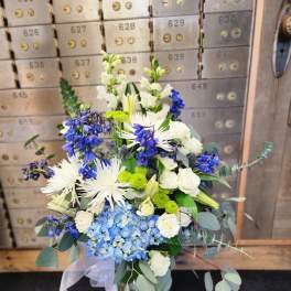 Blue and white mixed bouquet in a glass vase with ribbon