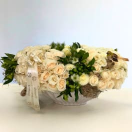 Cream rose arrangement in a white bowl with ribbon and bird accents
