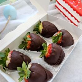 Box of chocolate-dipped strawberries in white paper cups