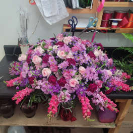 Large pink and purple floral arrangement with roses and daisies