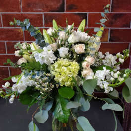 White and pale green floral arrangement in a glass vase