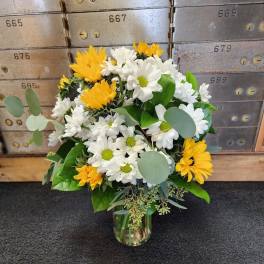 Yellow and white daisy bouquet in a glass vase