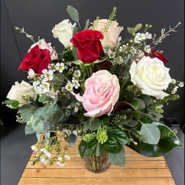 Bouquet of red, pink, and white roses in a glass vase