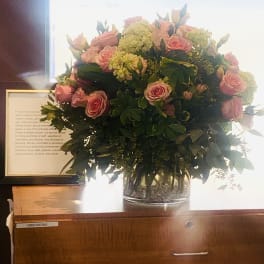 Large bouquet of pink roses and green hydrangeas in a clear glass vase