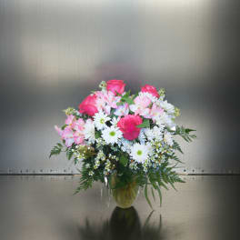 Bouquet of pink roses and white daisies in a clear glass vase