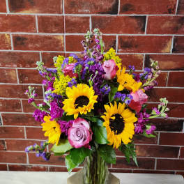 Mixed bouquet with sunflowers and pink roses in a glass vase