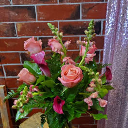 Pink roses and calla lilies in a glass vase
