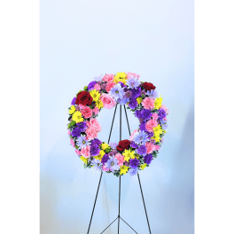 Colorful floral wreath on a black stand