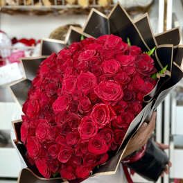 Large bouquet of red roses wrapped in black paper