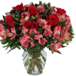 Bouquet of red roses and pink alstroemeria in a clear glass vase