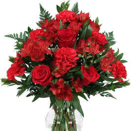 Red roses and carnations in a clear glass vase