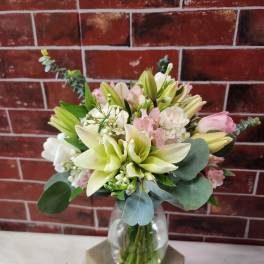 Bouquet of lilies and pink flowers in a clear glass vase