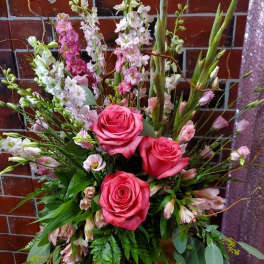 Pink roses in a glass vase with tall white and pink flowers