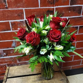 Bouquet of red roses and white lilies in a glass vase