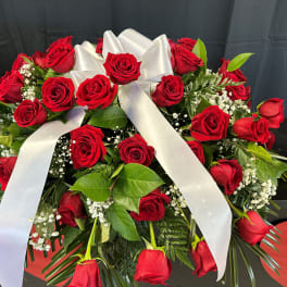 Red rose arrangement with a white ribbon bow