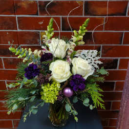 Bouquet of white roses and purple flowers in a glass vase