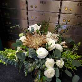 White and tan floral arrangement in a glass vase