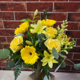 Yellow mixed bouquet in a gold vase with roses and lilies