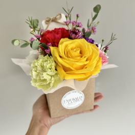 Small mixed bouquet in a kraft box with a yellow rose and red carnation