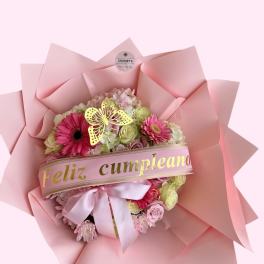 Pink flower bouquet with a birthday ribbon and butterfly decoration