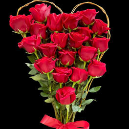 Heart-shaped bouquet of red roses tied with a red ribbon