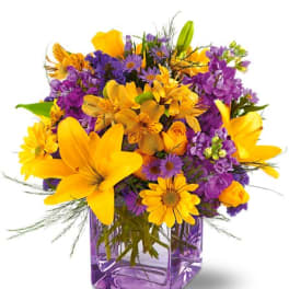 Yellow and purple mixed bouquet in a purple glass vase