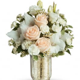 Peach roses and white flowers in a gold glass vase
