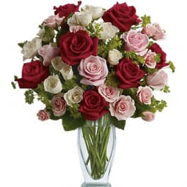 Bouquet of red, pink, and white roses in a clear glass vase