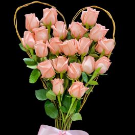 Pink roses arranged in a heart-shaped frame with a pink ribbon
