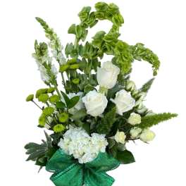 White roses and green flowers in a vase with a large green bow