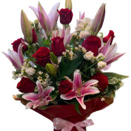 Bouquet of red roses and pink lilies wrapped in red paper