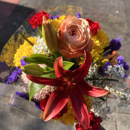 Mixed bouquet with a peach rose, red lily, and yellow flowers