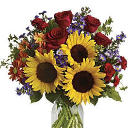 Bouquet of sunflowers, red roses, and purple flowers in a glass vase