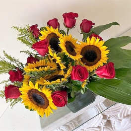Sunflowers and Red roses arranged in a vase