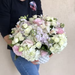 Large bouquet of white and pale pink flowers held in arms