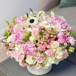 Pink and white mixed flower bouquet in a white vase